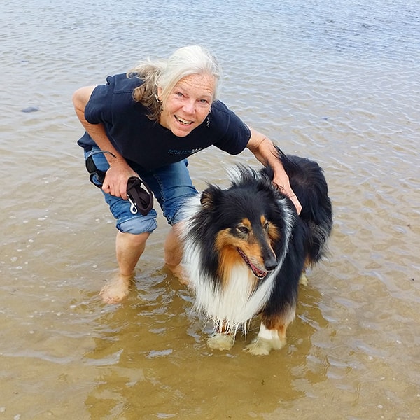 Crosspaws owner Sylvie and Jezz the collie standing in the surf